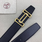 Leather belt with dark navy grain texture and gold-tone double H buckle beside strap.