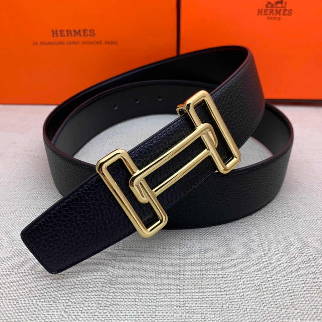 Leather belt with dark navy grain texture and gold-tone double H buckle close-up.