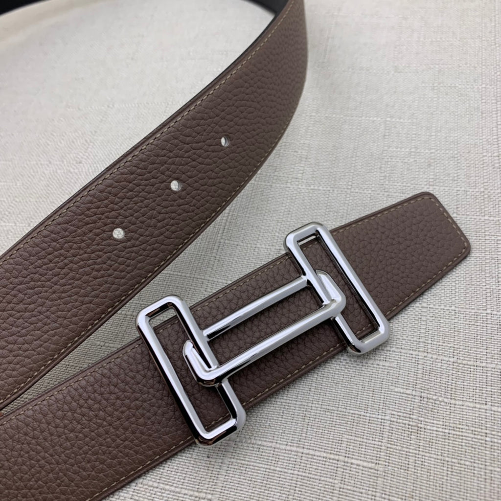 Brown leather belt close-up with silver-tone H buckle