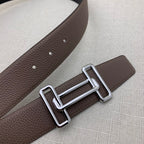 Brown leather belt close-up with silver-tone H buckle