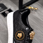 Versace black sneakers side view with gold lion emblem and ornate lace hardware
