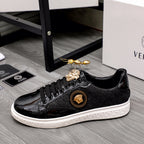 Versace black sneakers with gold crest medallion, glossy toe, and white sole