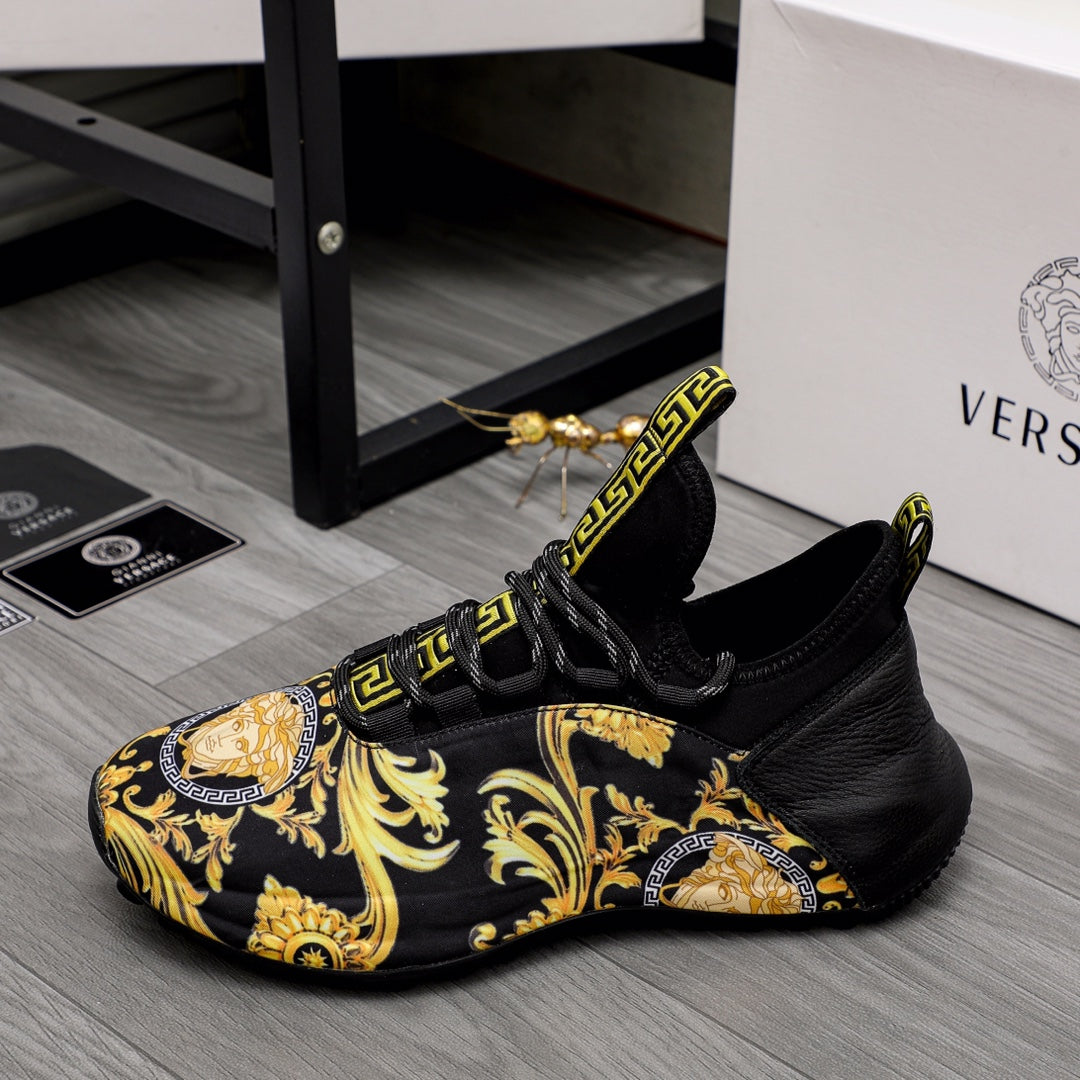 Black luxury sneakers with gold baroque pattern and Greca logo strap detail, side view