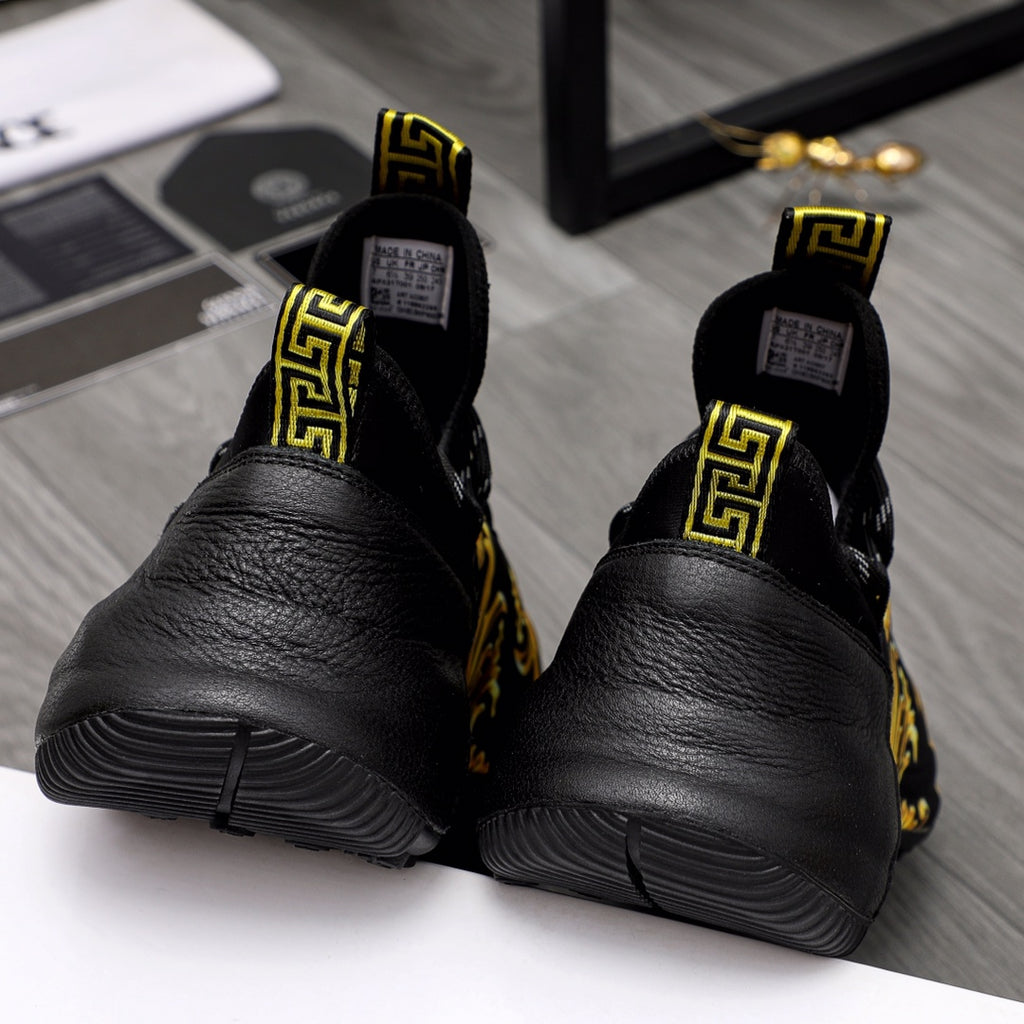 Black luxury sneakers with Greca logo heels and gold baroque side panels, rear view