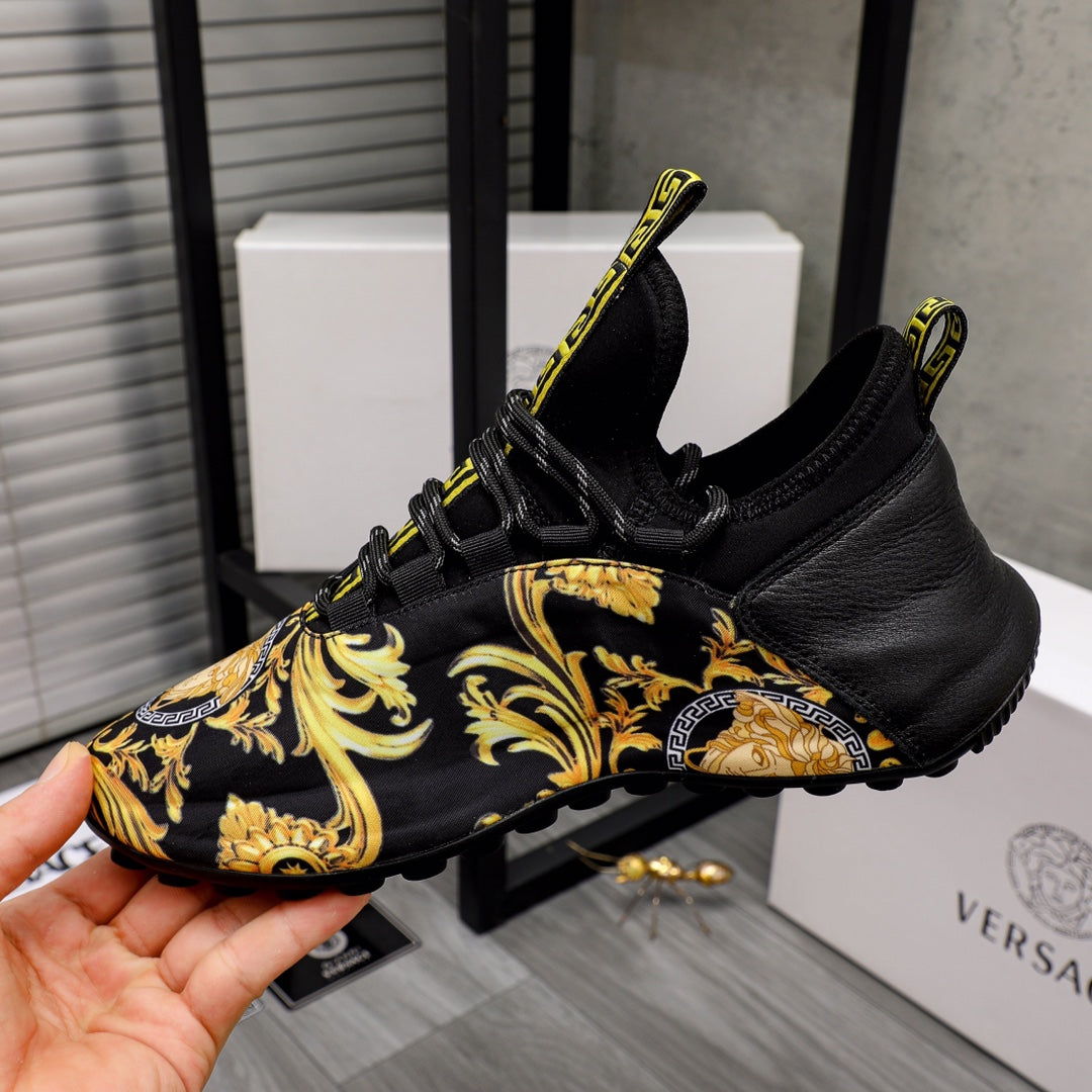 Black luxury sneakers with gold baroque side panel and lace-up design with Greca trim
