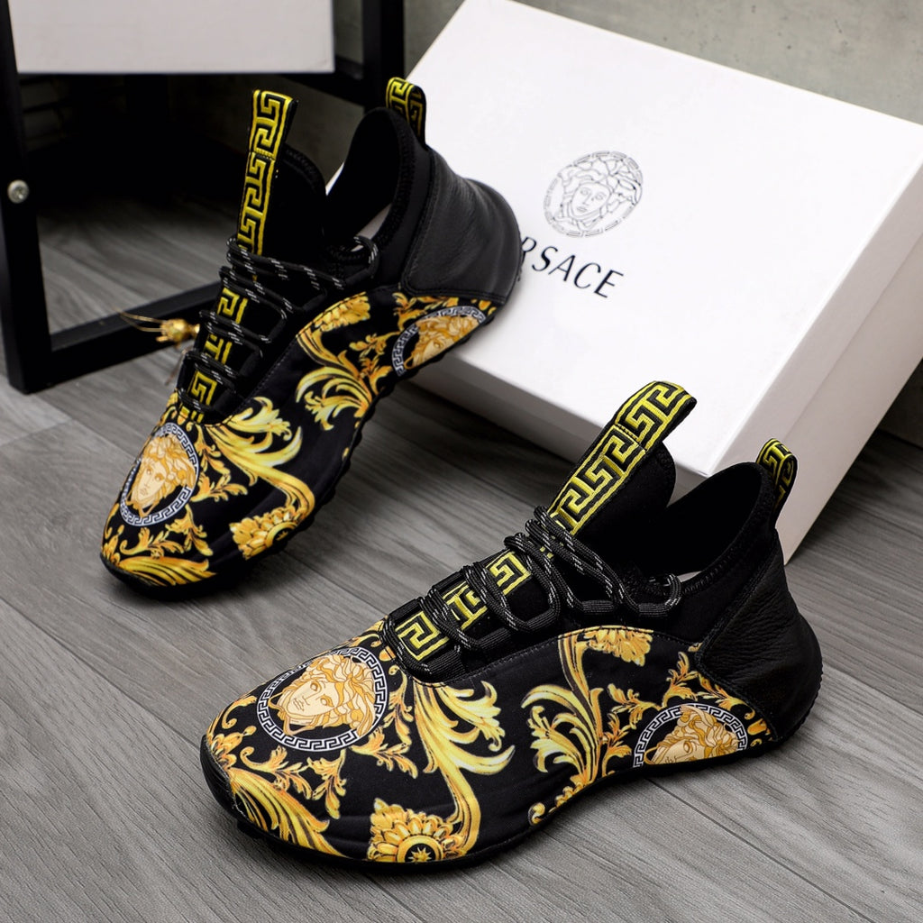 Black luxury sneakers with gold baroque print and Greca logo strap details