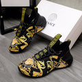 Black luxury sneakers with gold baroque print and Greca logo strap details
