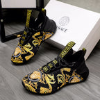 Black luxury sneakers with gold baroque print and Greca logo strap details