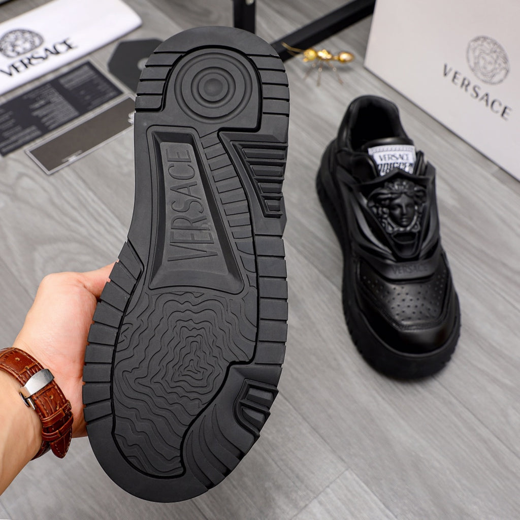 Black sneaker outsole and profile view with tread pattern and logo detail.