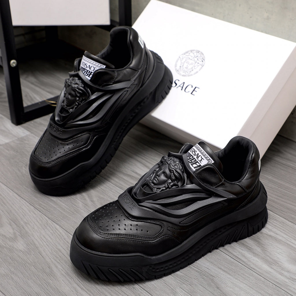 Black lace-up sneakers with chunky sculpted sole and Versace logo tongue label.