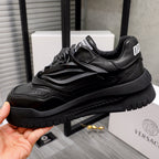 Black lace-up sneaker with raised side panels and chunky tread sole.