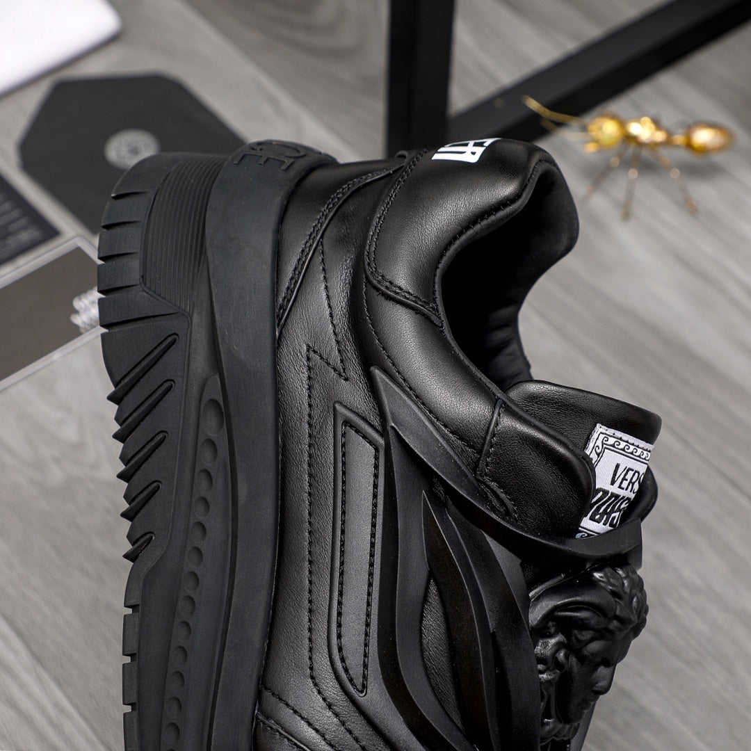 Black lace-up sneakers close-up of heel and side stripes with chunky sole.