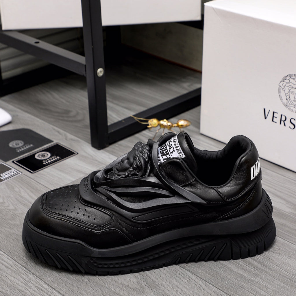 Black lace-up sneakers with layered straps and chunky rubber outsole.