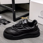 Black lace-up sneakers with layered straps and chunky rubber outsole.