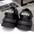 Pair of black sneakers with printed heel branding and thick ridged outsole.