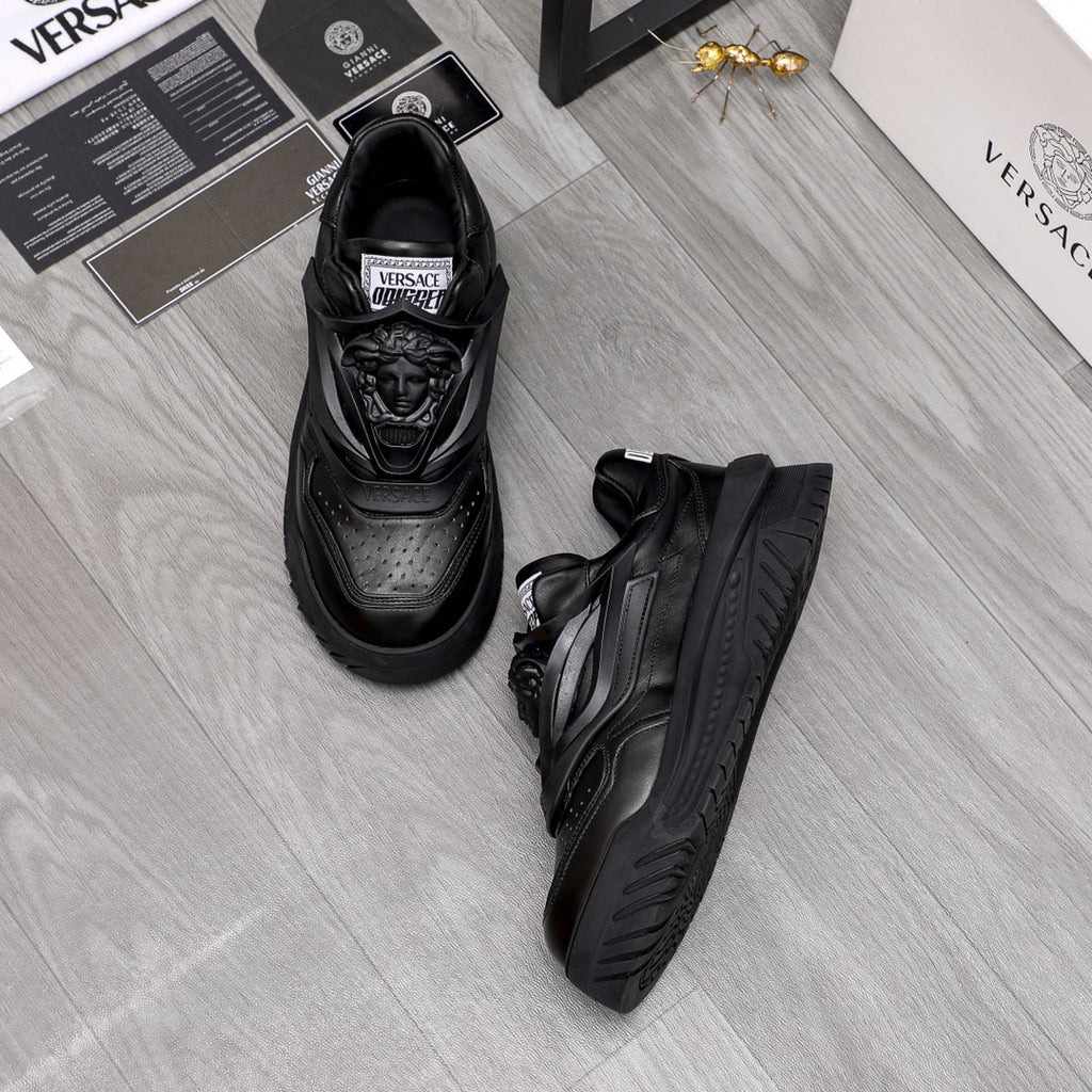 Black lace-up sneakers set with detailed toe perforations and molded sole.