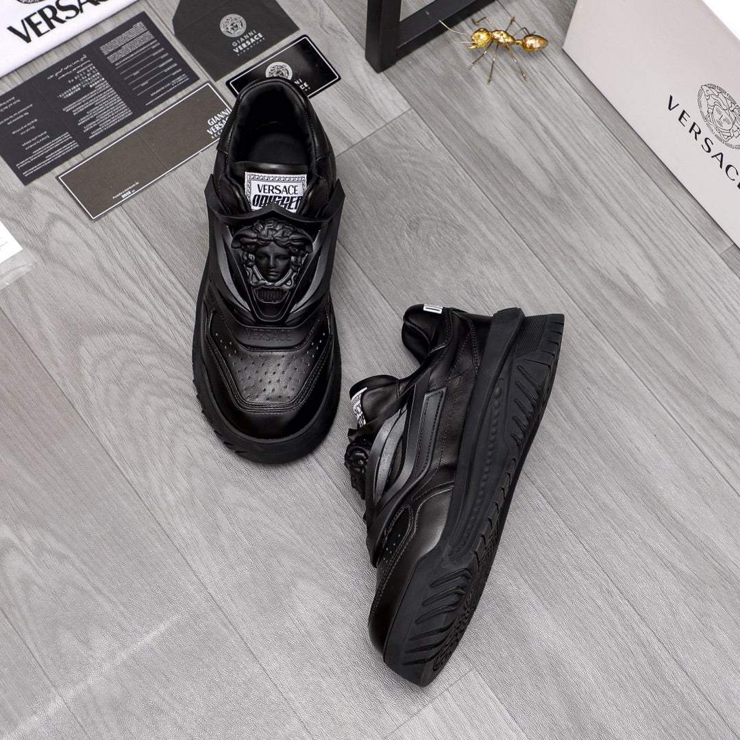 Black lace-up sneakers set with detailed toe perforations and molded sole.