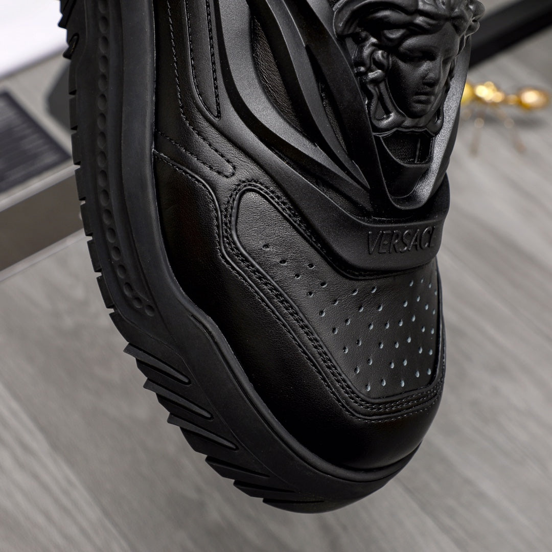 Black sneaker side view with perforated leather paneling and sculpted sole.