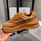 Luxury shoes: tan sneakers in hand, featuring raised strap detail and thick tread sole