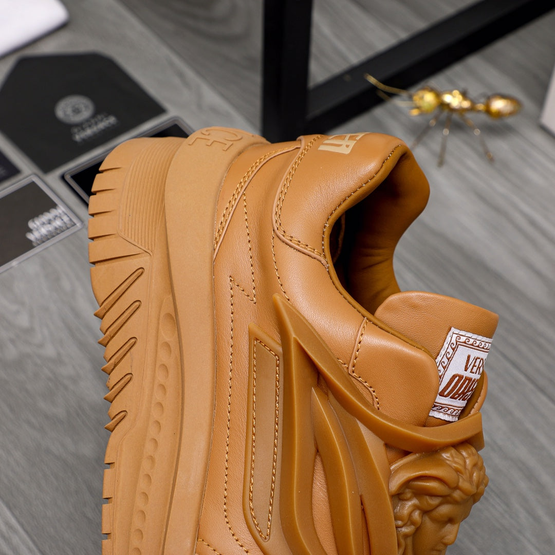 Luxury shoes: tan sneaker side view with cushioned collar and thick tread sole