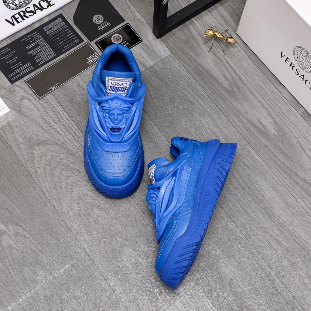 Blue Versace luxury sneakers pair on floor, lace-up with sculpted upper