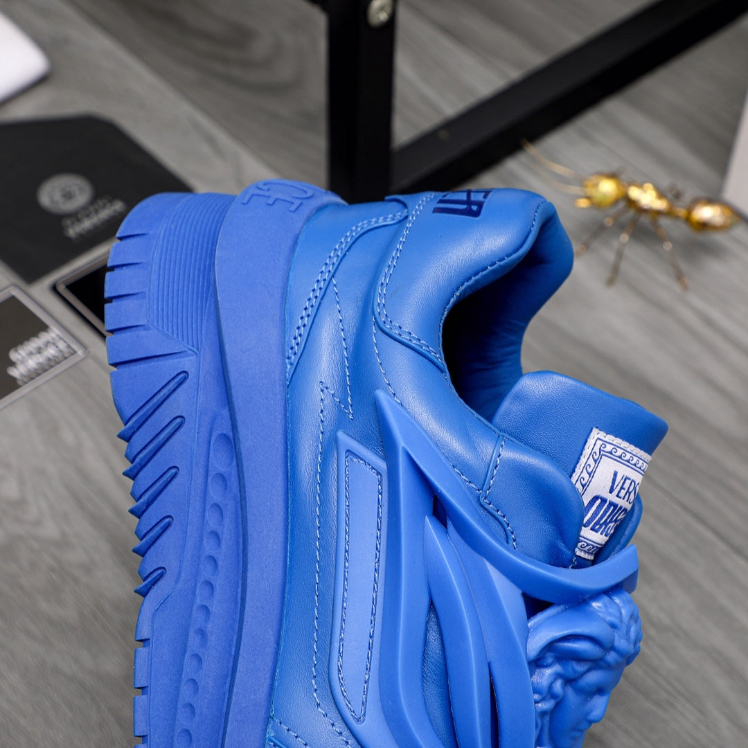 Blue Versace luxury sneakers side close-up with logo tab and thick sole