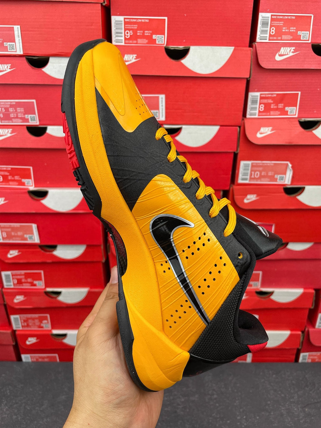 Yellow and black sneaker quarter view with Nike swoosh and lace-up front
