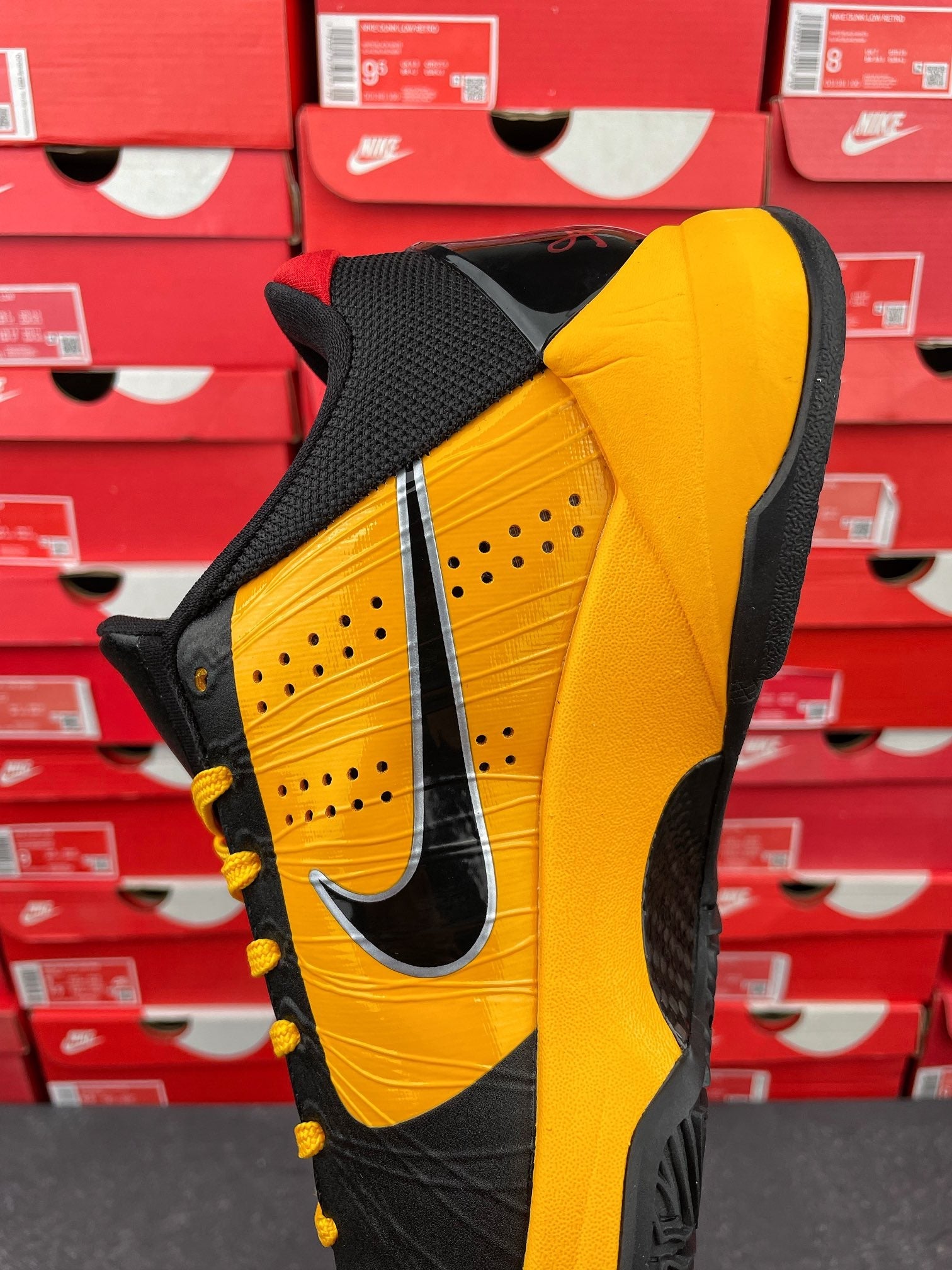 Yellow and black sneaker toe and side view with perforated panel and Nike swoosh