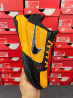Yellow and black sneaker side view with lace-up and large Nike swoosh