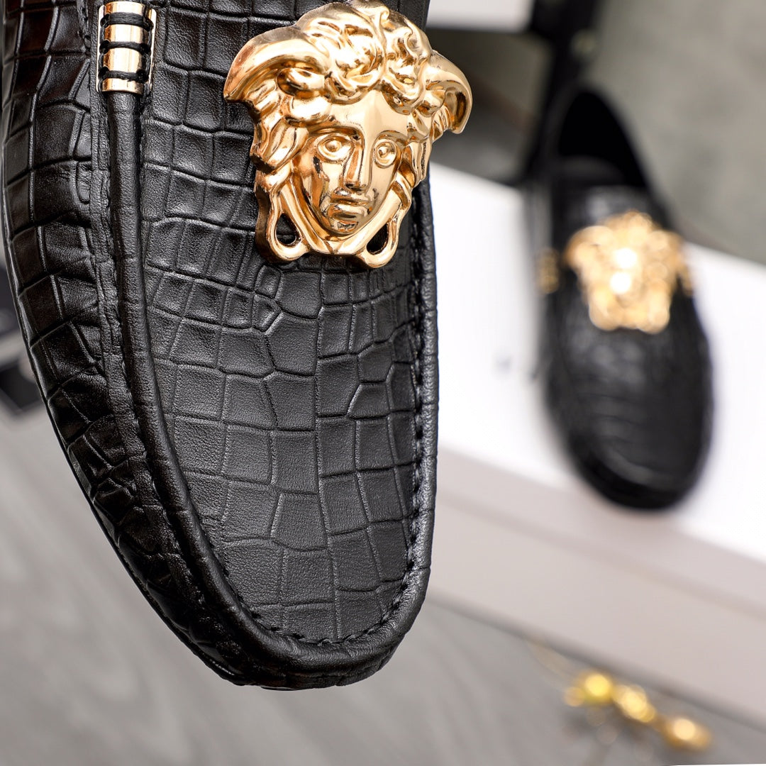 Versace black loafer upper close-up with gold lion head medallion and metal bars