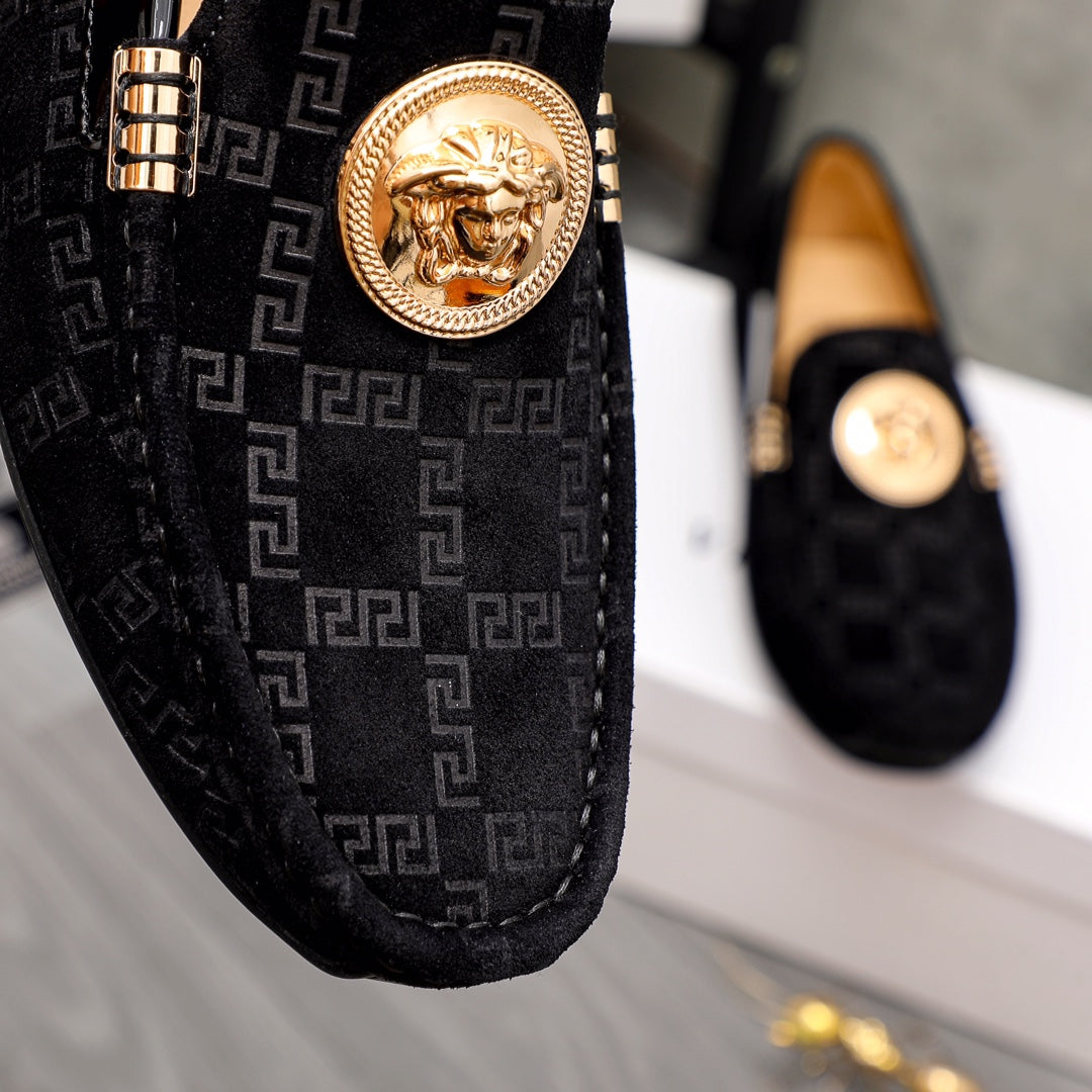Versace black loafer detail with gold lion medallion and Greca woven pattern