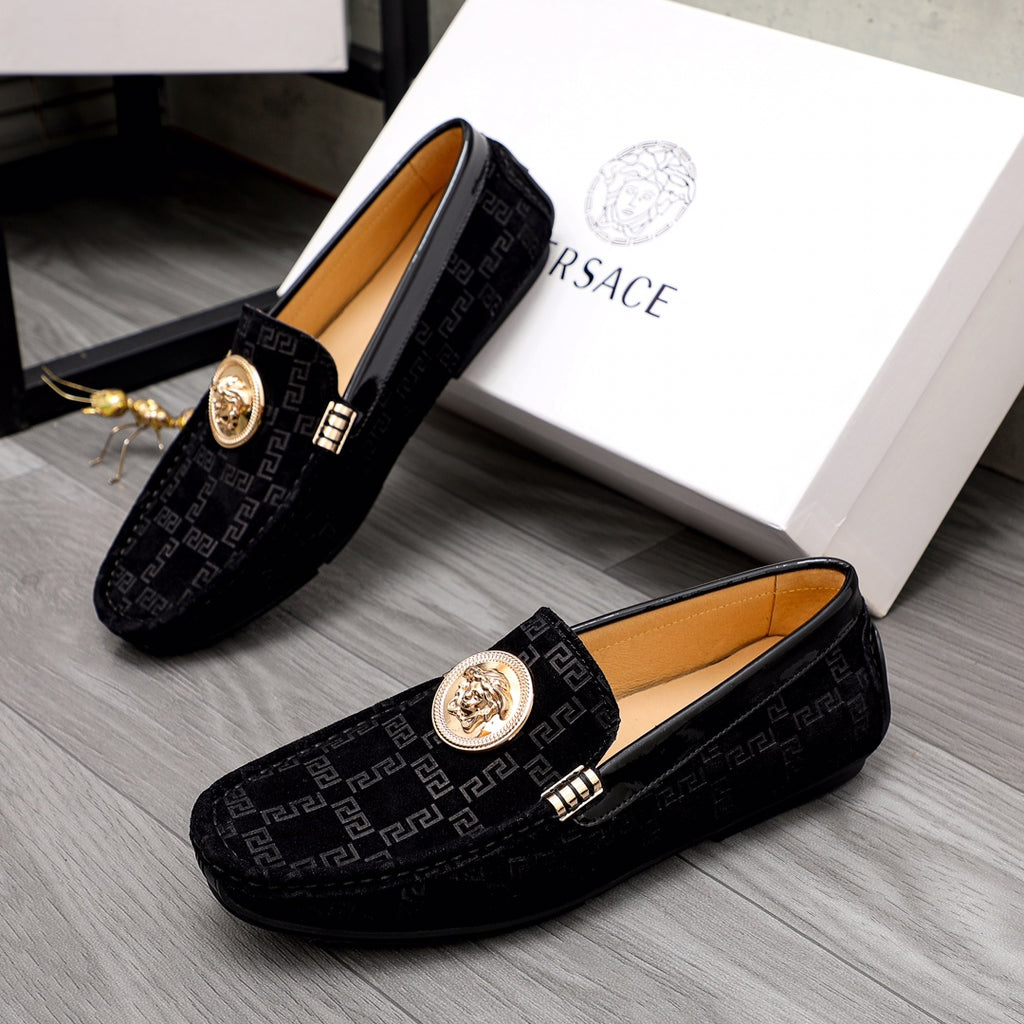 Versace pair of black loafers with Greca pattern, gold medallion bits, and buckle accents