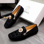 Versace pair of black loafers with Greca pattern, gold medallion bits, and buckle accents