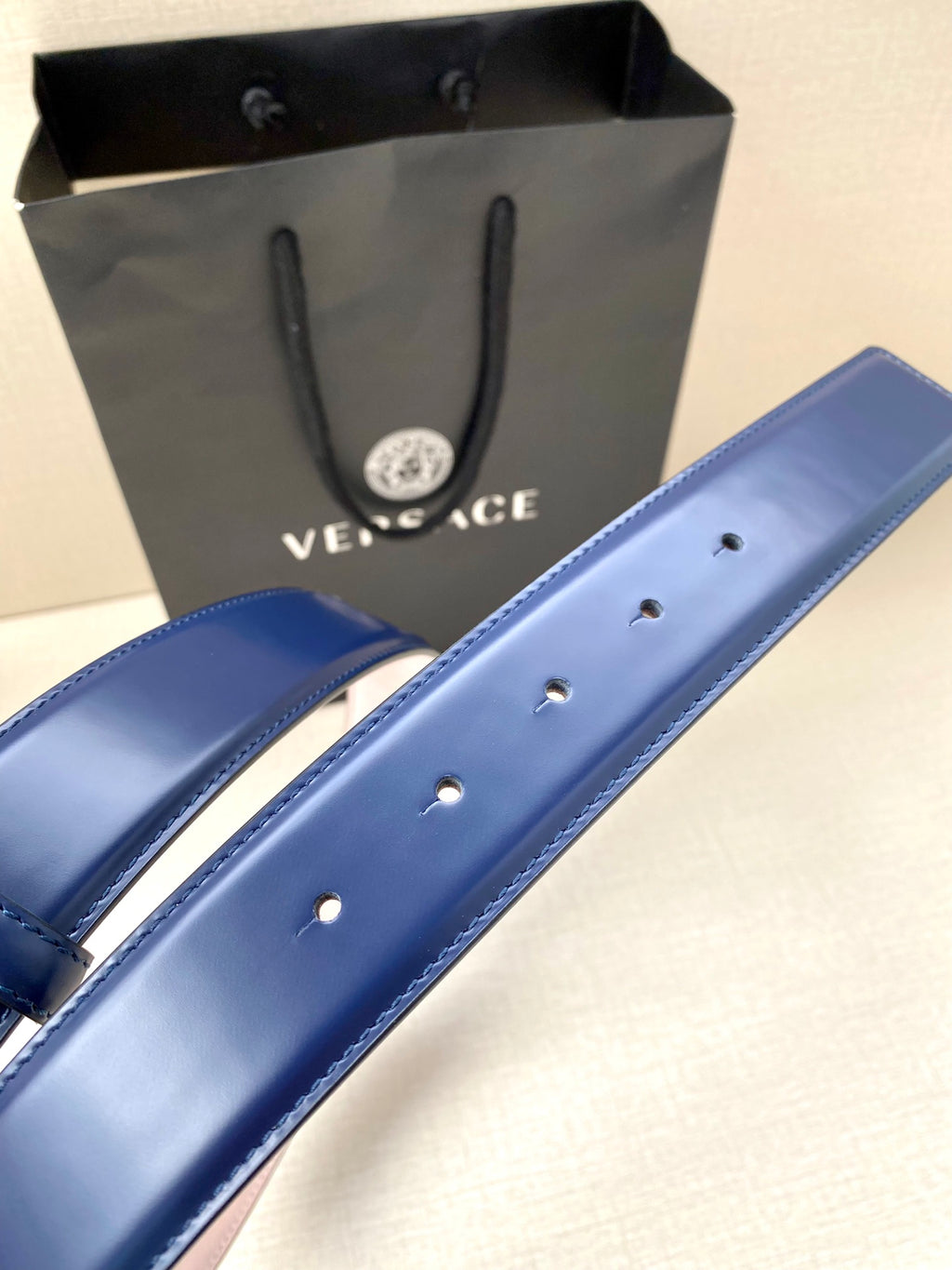 Blue leather belt with punched holes on the strap and smooth finish