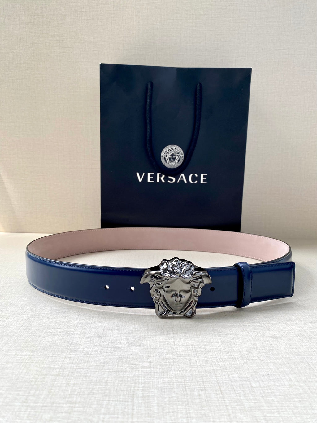 Blue leather belt with silver lion-head buckle and multiple holes