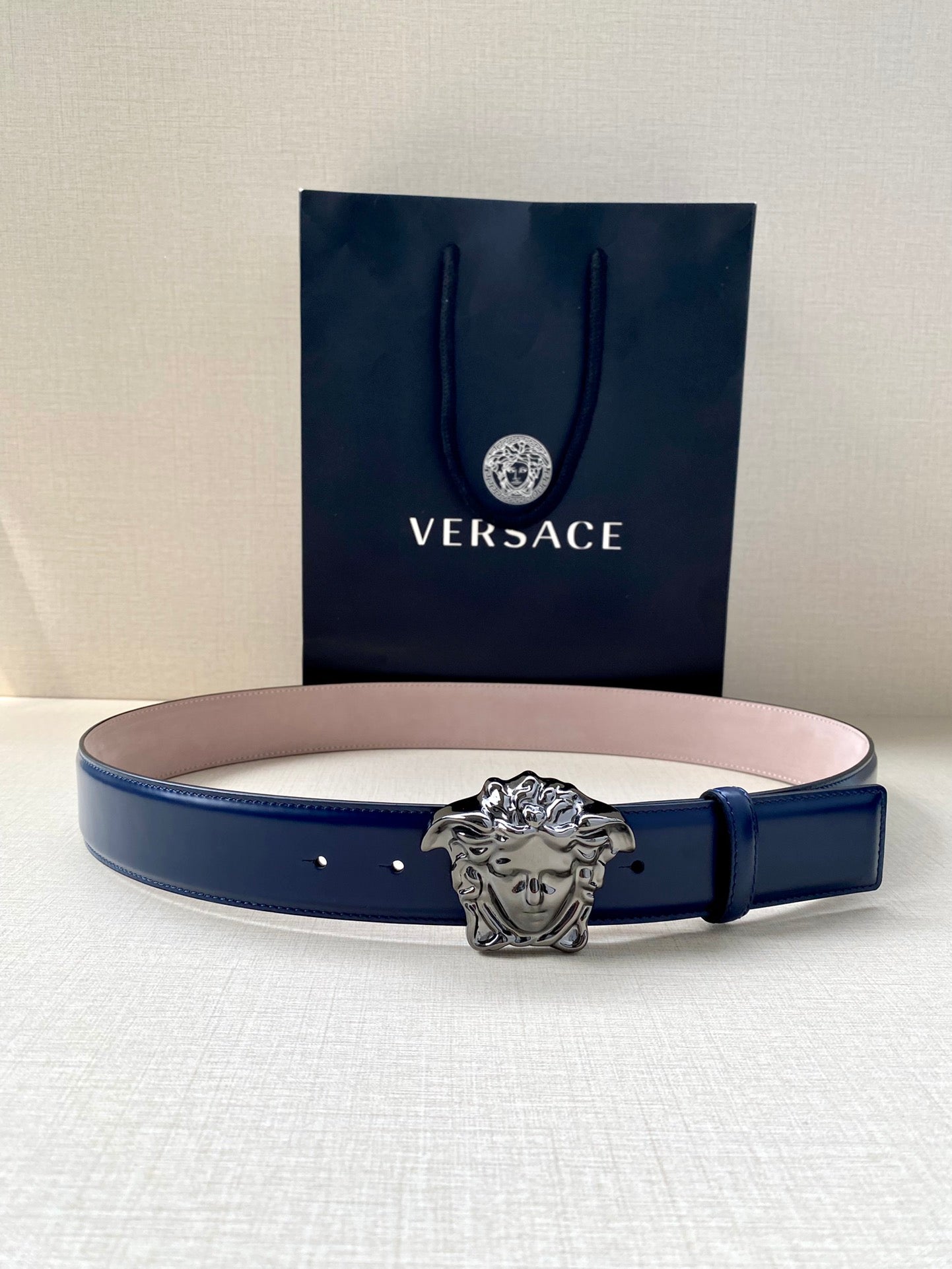 Blue leather belt with silver lion-head buckle and multiple holes