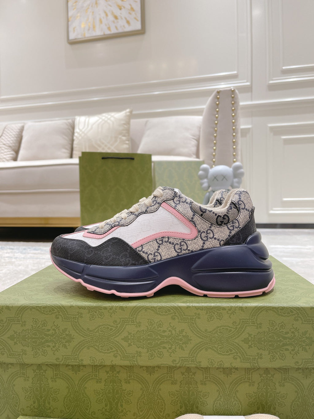 Gucci unisex sneakers side view, GG canvas upper with pink edging and dark navy midsole.