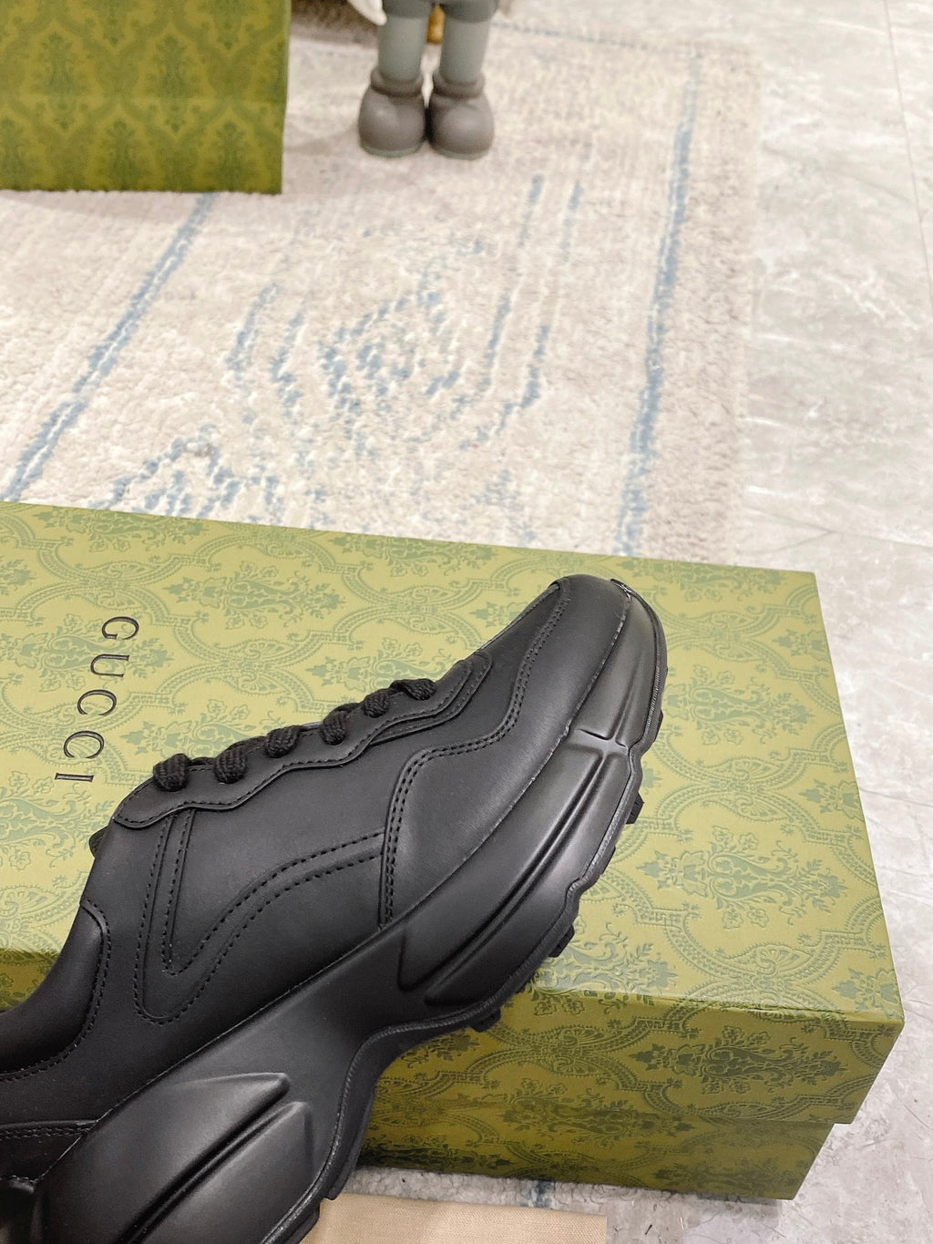 Dark/black Gucci sneaker toe and side, lace-up with stitched panels and sculpted sole