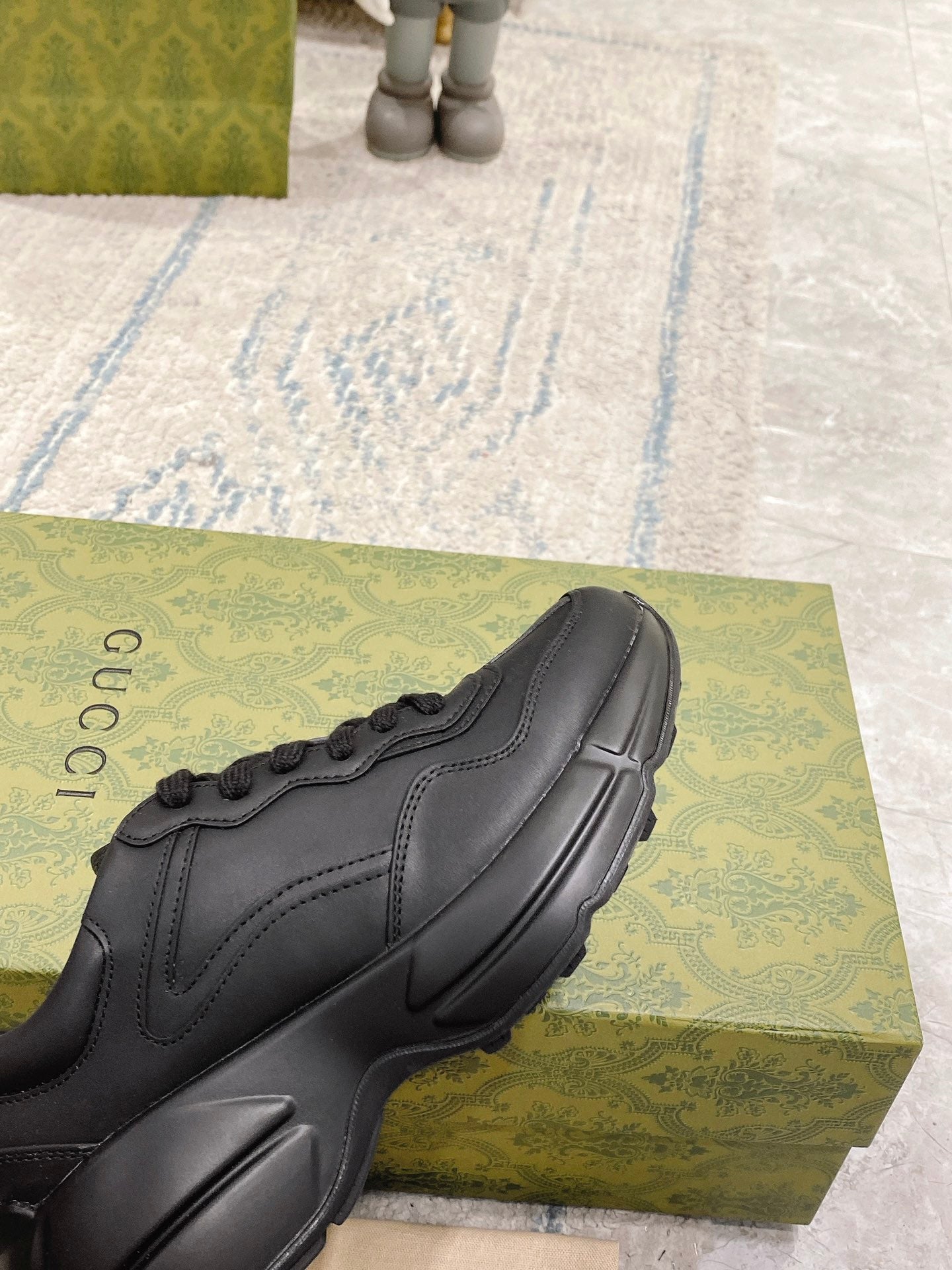 Dark/black Gucci sneaker toe and side, lace-up with stitched panels and sculpted sole