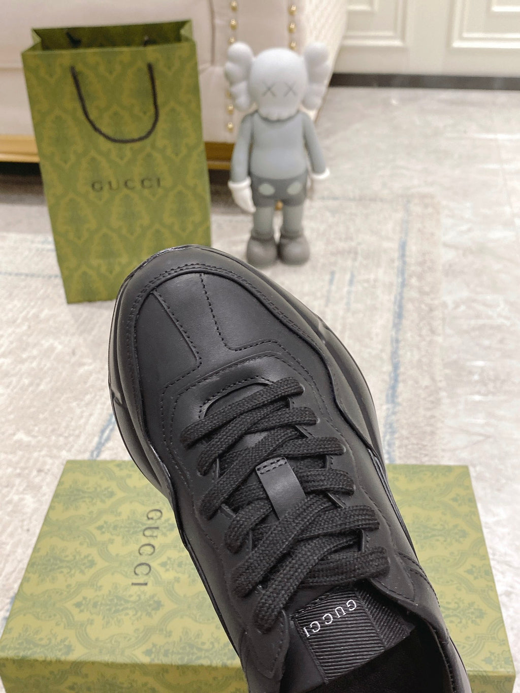 Dark/black Gucci lace-up sneaker close-up, front view with eyestays and stitching