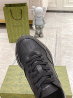 Dark/black Gucci lace-up sneaker close-up, front view with eyestays and stitching