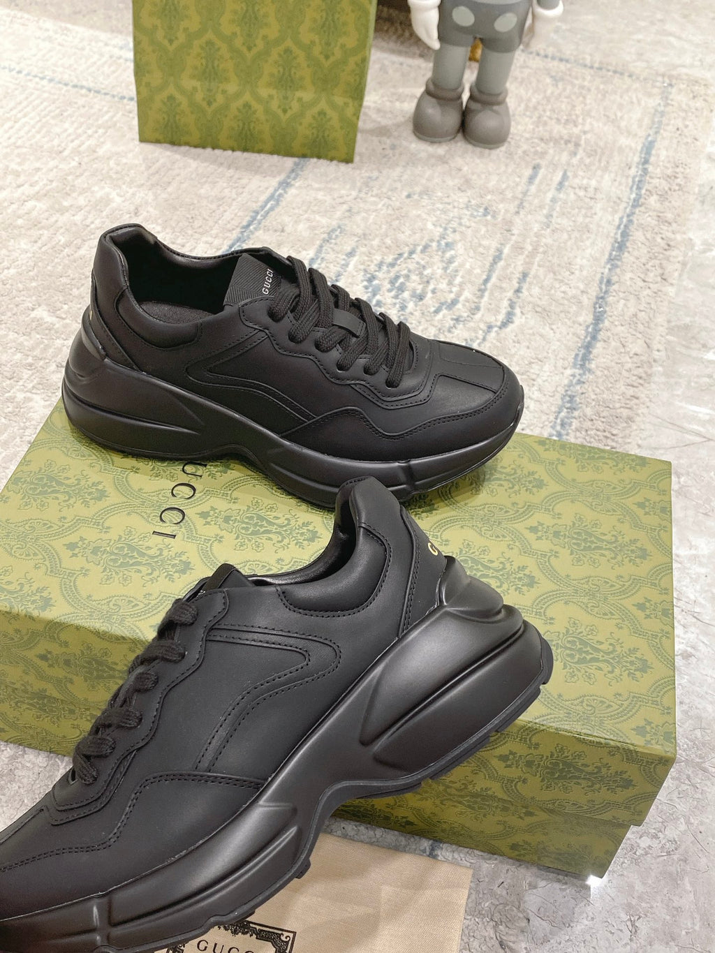 Gucci dark/black lace-up sneakers, side profile with textured overlays and thick sole