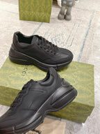 Gucci dark/black lace-up sneakers, side profile with textured overlays and thick sole