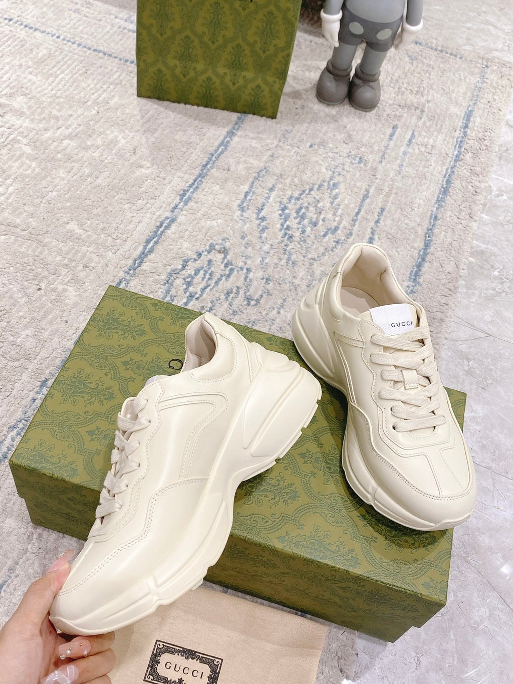 White Gucci unisex sneakers side view on green box with lace-up details