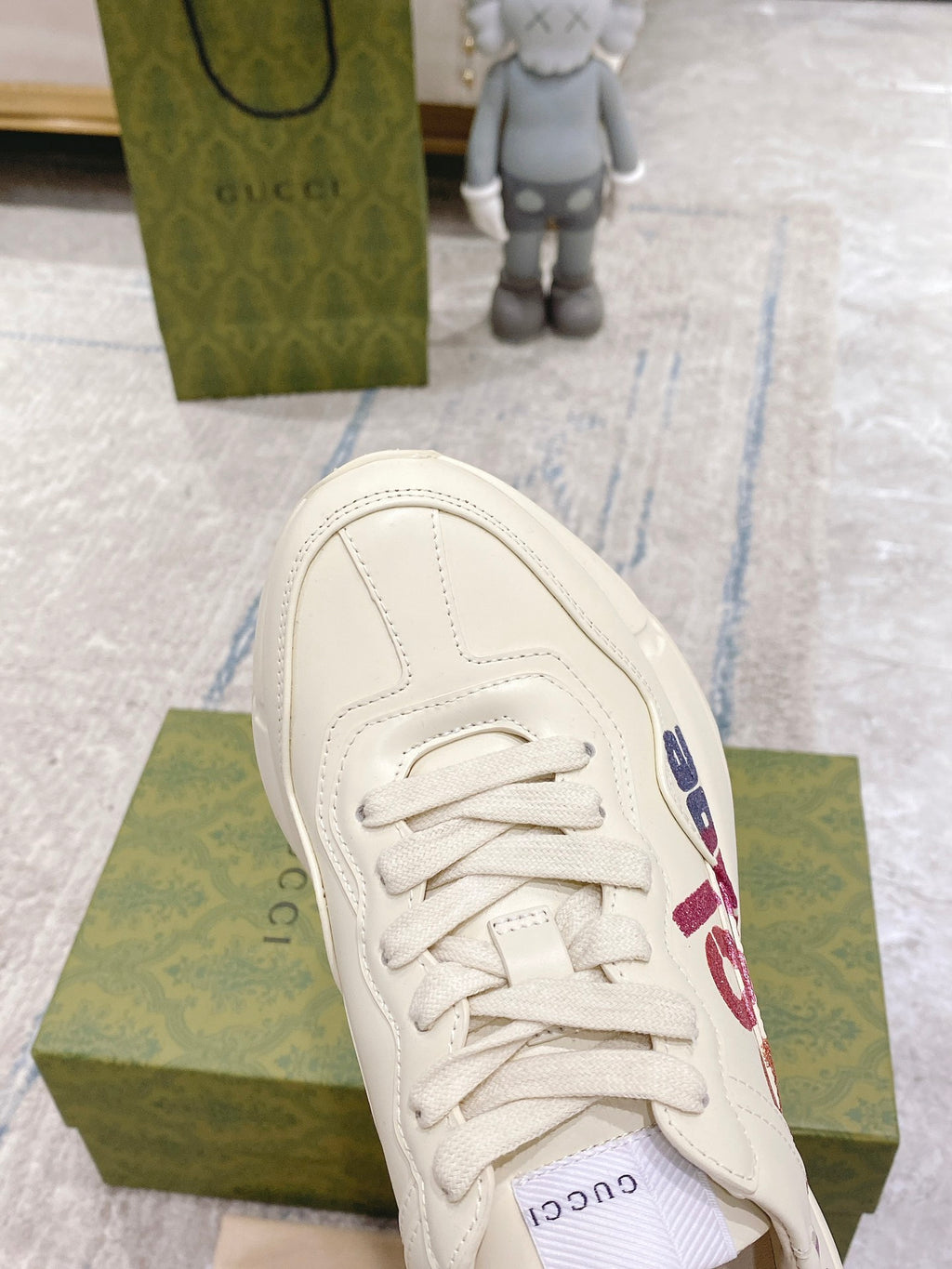 White Gucci unisex sneaker toe view with laces and side graphic detail