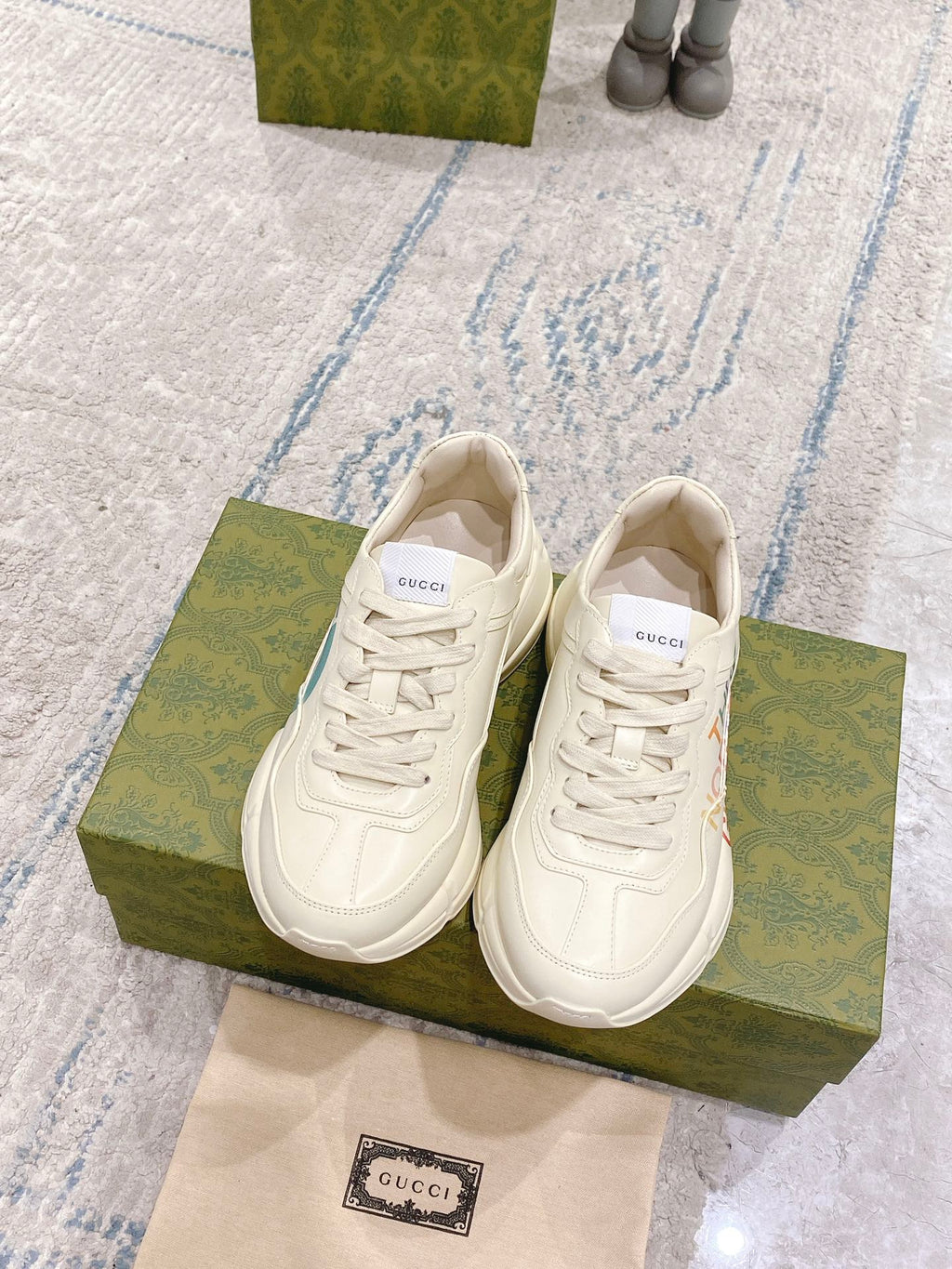 White lace-up sneakers, top view, with Gucci label on insole