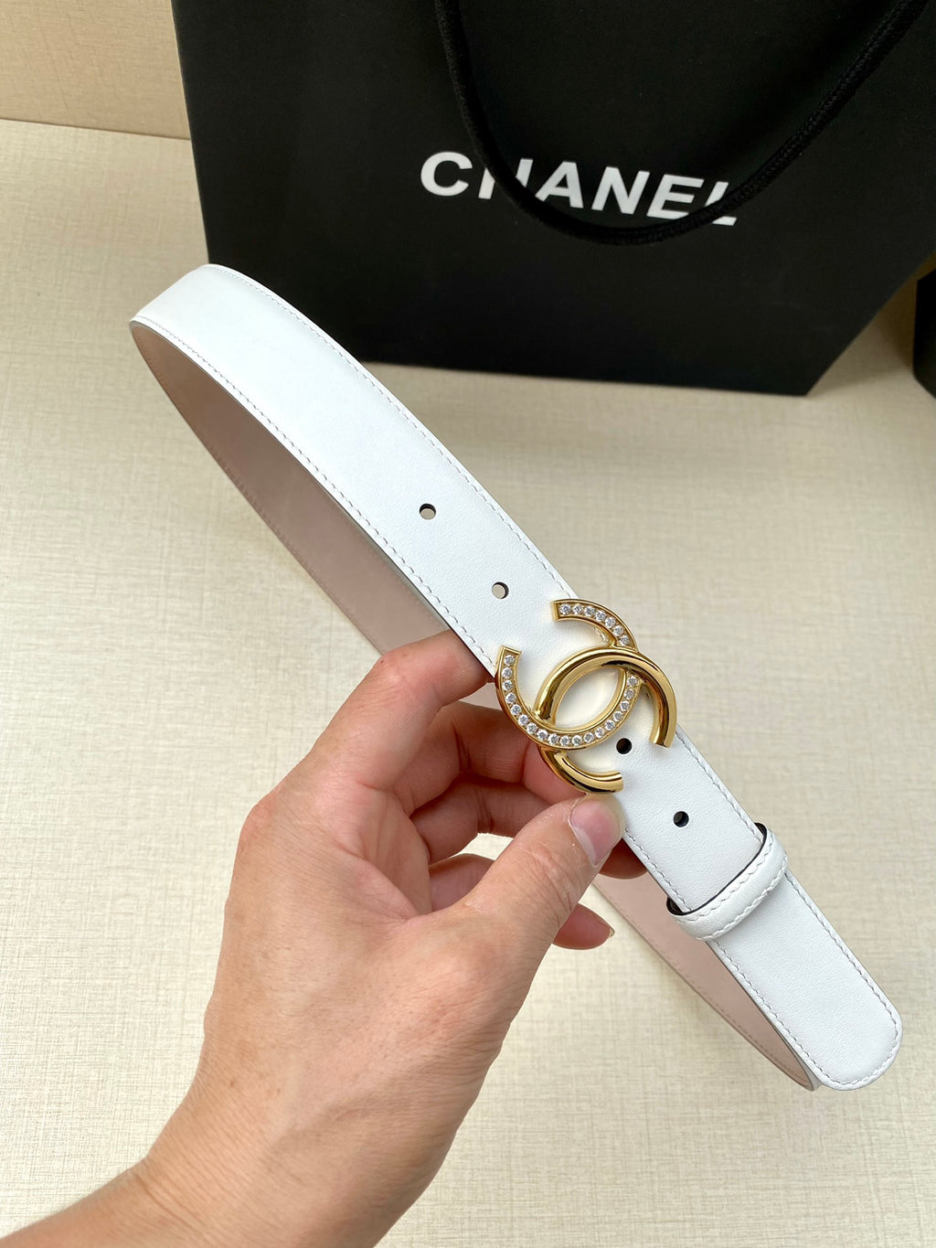 White leather belt with gold CC buckle and punched adjustment holes