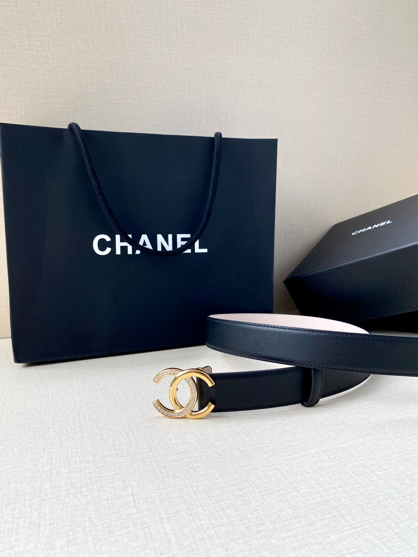 Chanel leather belt with dark blue strap and gold CC buckle, laid flat