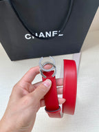 Red leather belt with silver-tone CC buckle close-up, light pink inner lining.