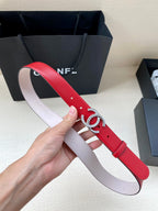 Red leather belt with silver-tone CC buckle, light pink underside, pin holes visible.